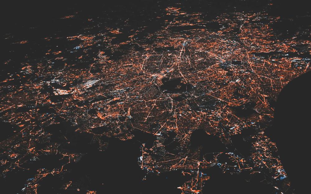 Aerial night view of a city grid glowing like an interconnect network